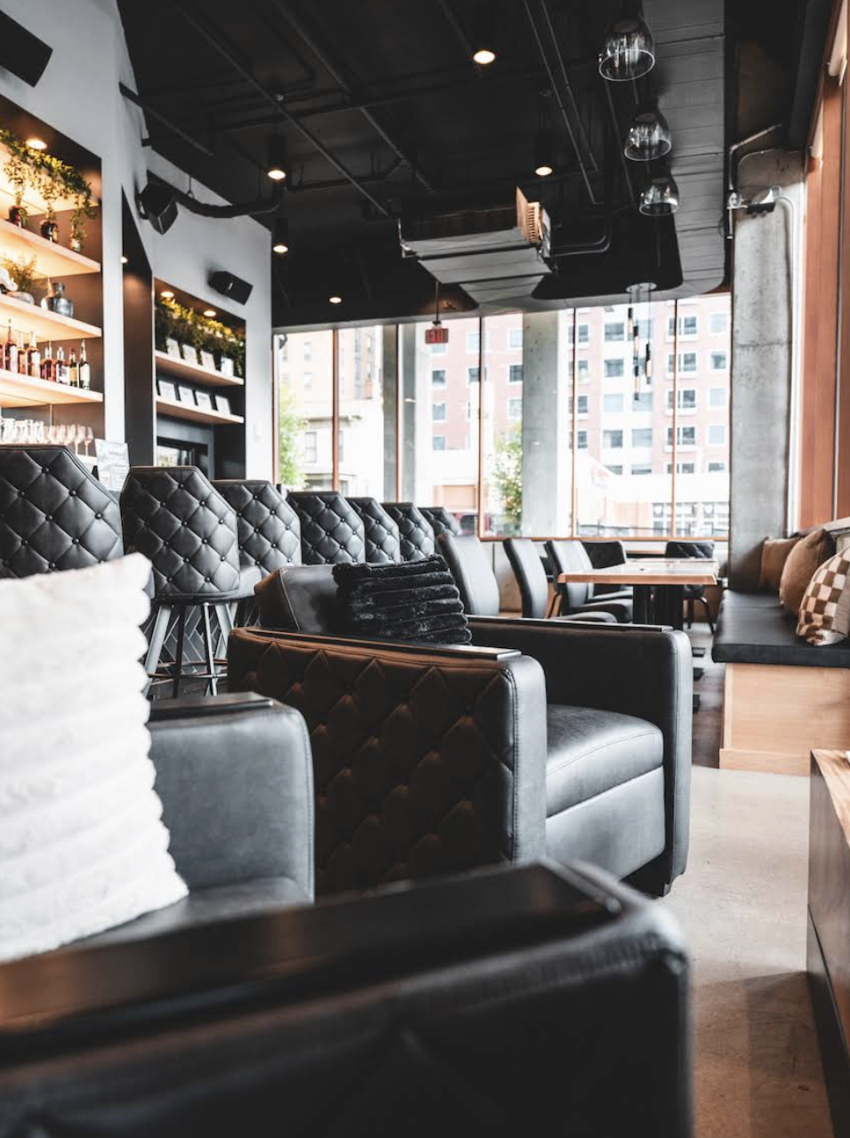 Tufted leather lounge chairs and bar shelving at 1824 in Ann Arbor